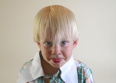 A little blond boy with his hair combed forward.