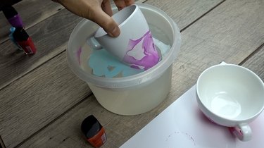 Double dipping nail polish marbled mugs into second color.