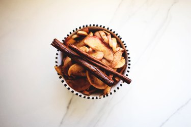 Roasted apples and cinnamon stick set aside to cool.