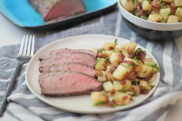 Sliced tri-tip on a plate with potato salad
