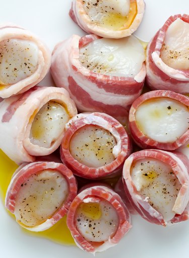 Wrapping the scallops in bacon.