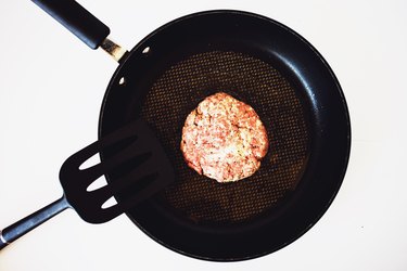 A burger patty in a frying pan.