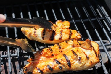 Chicken being flipped on a grill