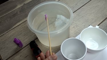 Skimming excess polish off the surface of the water nail polish marbled mugs