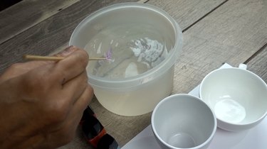 Skimming excess polish off the surface of the water nail polish marbled mugs