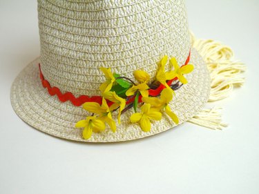 Yellow silk flowers glued to the side of the hat in a cluster.