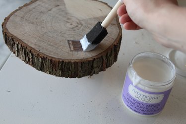 Brushing varnish on the wood with a foam brush