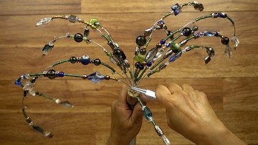 Inserting beaded wires into cork for DIY glass beaded garden sparkler.