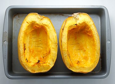 Roasting pan with baked spaghetti squash halves.