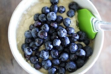 Bowl of muffin batter and blueberries.
