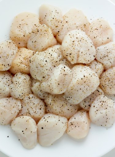 Season scallops with salt and pepper.