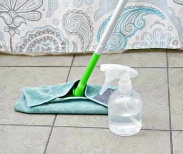 Mop on tile floor with vinegar bottle