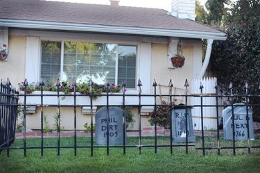 A faux rusted fence surrounding fake tombstones