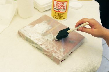 Foam brush apply even amounts of mod podge on book/paper towel.
