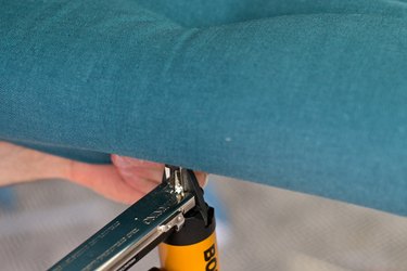 Secure the sides of the fabric underneath the board with the staple gun.