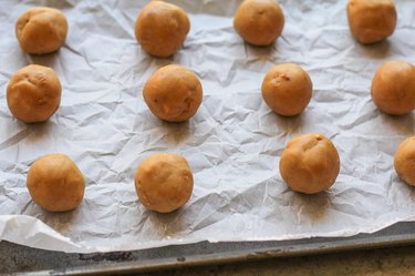 Balls of cookie dough on  a baking sheet