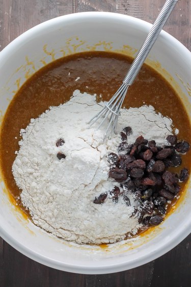 Folding the raisins and nuts into the batter.