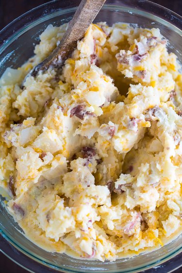 Mash potatoes with butter, cream, and cheese
