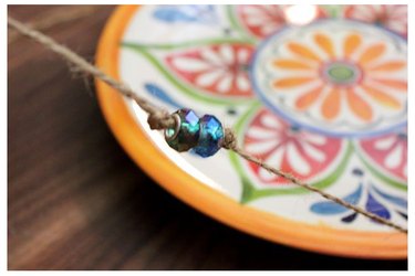 Add beads to string on plate.