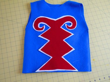 The design glued to the front of the blue vest.