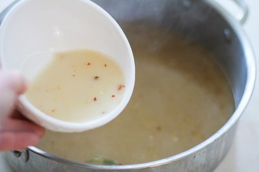 Cornstarch mixture being poured into broth