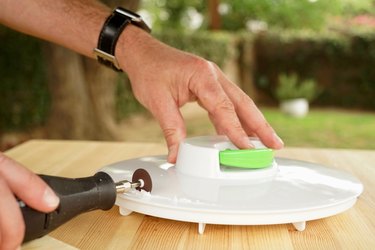 A rotary tool cuts into a salad spinner top