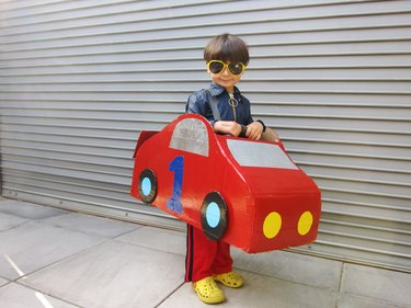 little boy wearing a red race car costume