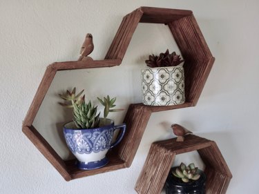 DIY hexagon, honeycomb shelves made using popsicle sticks, hot glue, and wood stain.