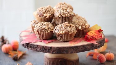 Streusel-topped muffins displayed on a wooden pedestal