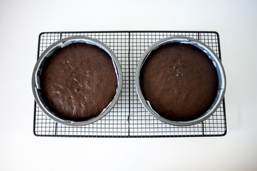 Two cake pans cooling on a rack.
