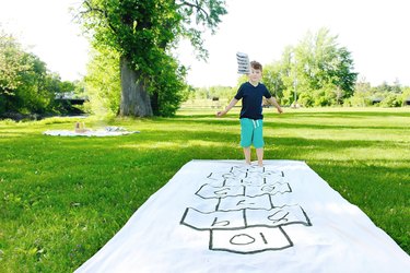 little boy playing on a portable DIY hopscotch board