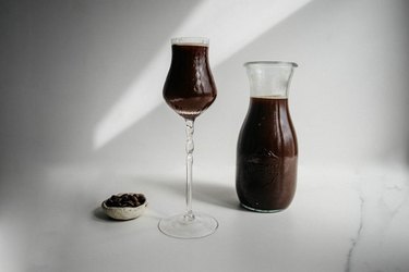 chocolate-infused vodka in glass next to filled carafe