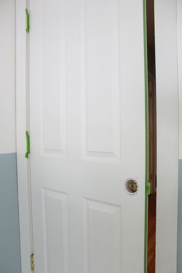 Remove the door knob and apply painter's tape.
