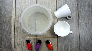 Materials for nail polish marbled mugs on table.