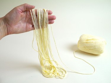 Yarn looped around a hand.
