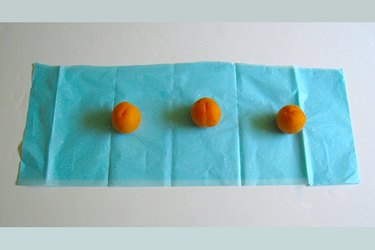 three apricots lined up on tissue paper
