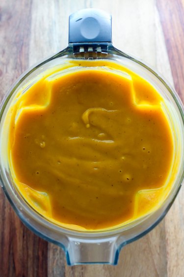Pureed butternut squash soup in a blender.