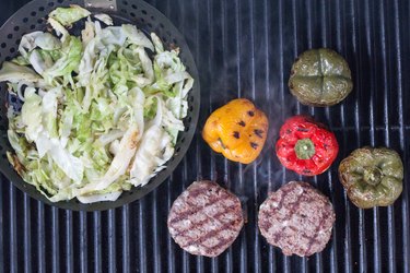 Grilling hamburgers, peppers and cabbage