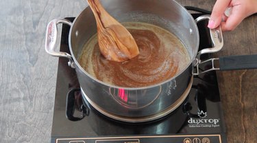 Stirring pumpkin pie spice into caramel mixture.