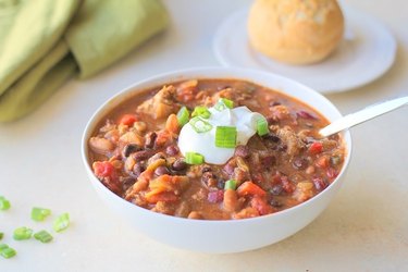 Bowl of chili with sour cream and green onion