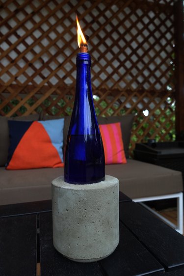 DIY concrete tabletop tiki torches out of used glass bottles.