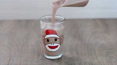 Fill sock monkey glass with chocolate milk