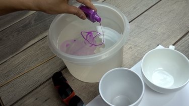 Pouring nail polish in warm water for nail polish marbled mugs.