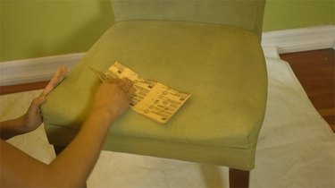 Sanding a dry coat of chalk paint on fabric upholstery.
