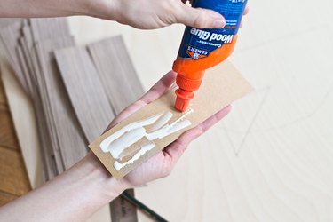 Place glue on the back of the veneer strips.
