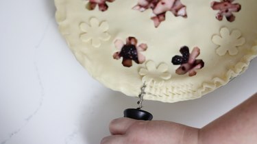 Pressing corkscrew into edge of dough