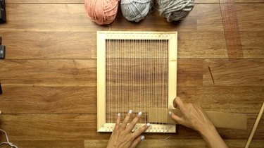 Using a cardboard spacer for an easy DIY woven wall hanging.