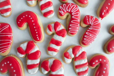 Sugar cookies shaped like candy canes with red and white frosting.