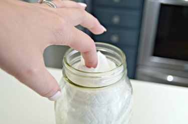 Adding paper towels to jar with cleaning solution