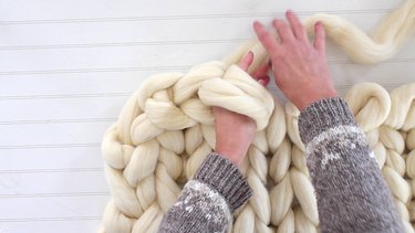 reach hand through the two loops and grab the yarn
